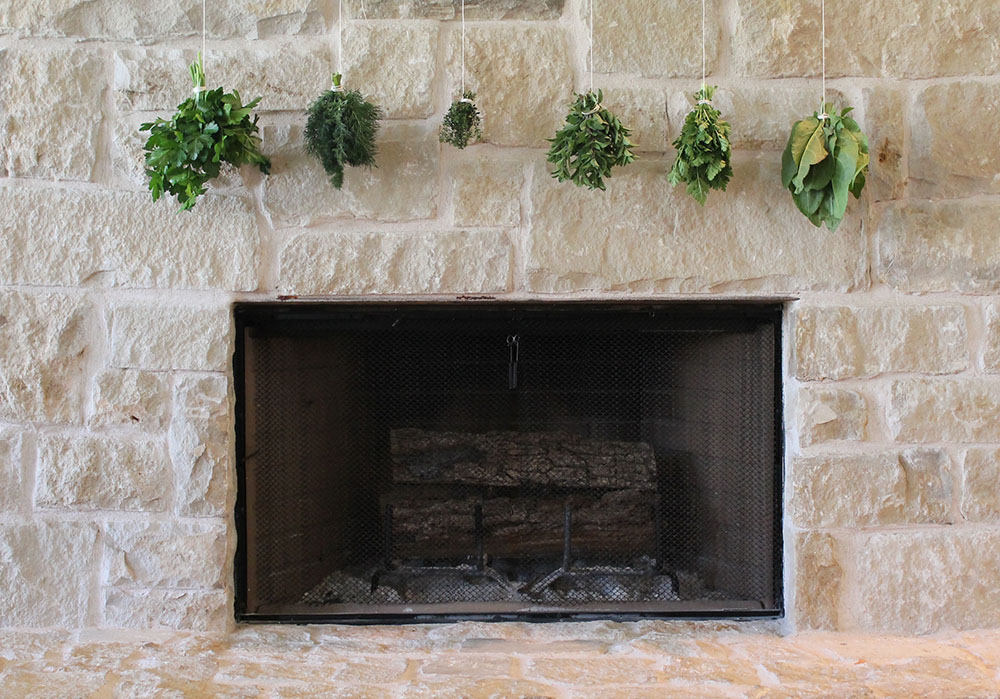 Hanging herbs to dry over the fireplace
